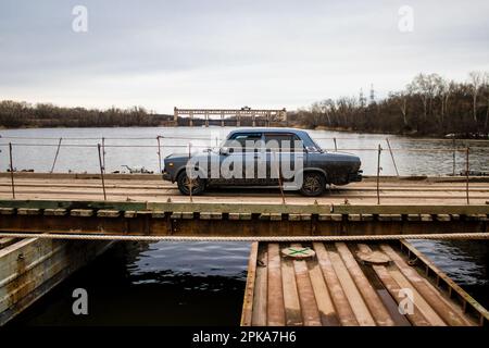 Destroyed bridge in war zone connecting Sloviansk and Lyman in the Donbas. A floating bridge was installed by the Ukrainian Armed Forces to facilitate Stock Photo