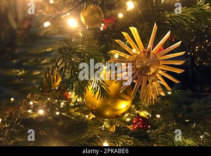 15.12.2022, Germany, , Berlin - Balls and straw stars hanging from a Christmas tree. 00S221215D838CAROEX.JPG [MODEL RELEASE: NOT Applicable, PROPERTY Stock Photo
