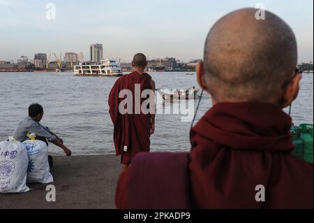 22.11.2013, Myanmar, , Yangon - Buddhist monks wait for ferries and river taxis on the southern bank of the Yangon River, while the former capital's b Stock Photo
