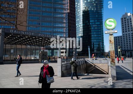 28.02.2023, Germany, , Berlin - Europe - People pass between the high-rise buildings and the entrance to the underground tunnel station of the S-Bahn Stock Photo
