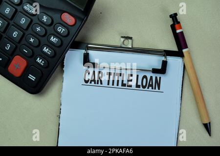 Concept of Car Title Loan write on paperwork isolated on Wooden Table. Stock Photo