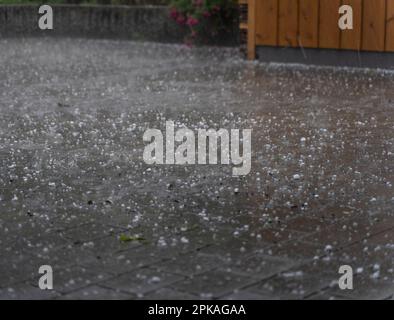 Hail and rain on a parking lot, thunderstorm in Garmisch-Partenkirchen, Bavaria, Germany Stock Photo