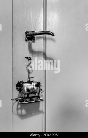 Christmas tree figure of a cow on a sleigh hangs on a door handle of an old building apartment Stock Photo