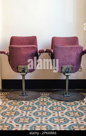 Vintage cinema chairs on an old cement tile floor in old building Stock Photo