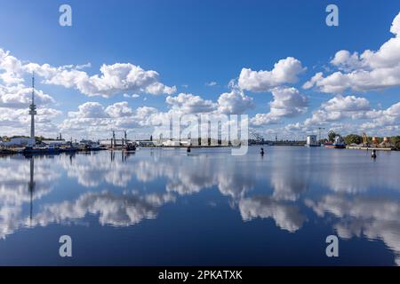 View from the lock road to the equipment harbor, with antenna tower of the Waterways and Shipping Authority Wilhelmshaven, clouds reflected in the water, Wilhelmshaven, Lower Saxony, Germany Stock Photo