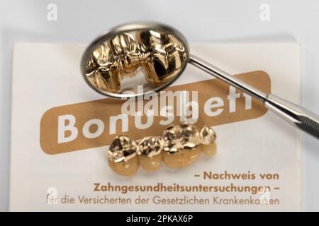 Bonus book, used partially veneered dental bridge, mouth mirror, detail, symbol image, denture, co-payment, white background, Stock Photo