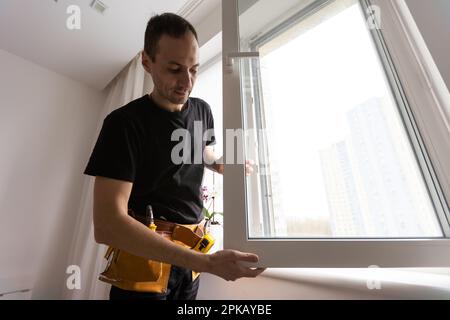 Worker in installing rubber seals on plastic upvc window. Stock Photo