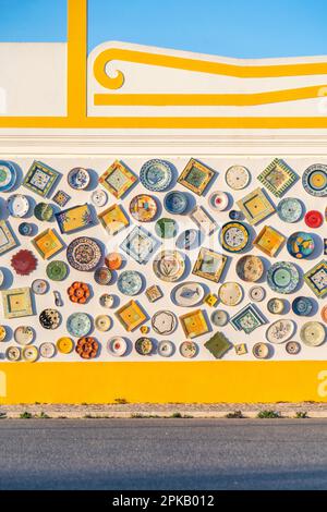 Portuguese traditional ceramics at pottery, local handcrafted portuguese products. Wall with ceramic plates in Sagres, Algarve, Portugal. Stock Photo