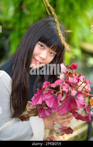 Young Asian Woman Shopping for Plants | Holding Potted Plant | Smiling Stock Photo