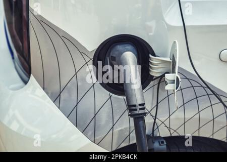 Electric car charging connect to electric car. Power cable pump plug in charging power to electric vehicle EV car with modern technology. Stock Photo