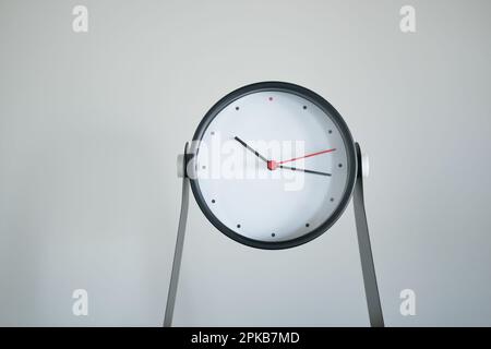 simple modern clock against white wall  Stock Photo