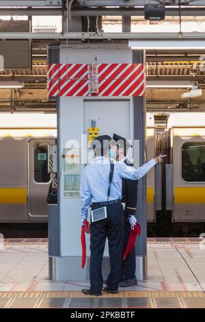 Japan, Honshu, Tokyo, Shinjuku Train Station, Two Platform Guards Stock Photo
