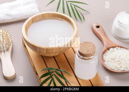 Homemade cosmetic rice water with ingredients and beauty kit on beige background, healthy beauty treatment ingredients for homemade comsetics, beauty Stock Photo