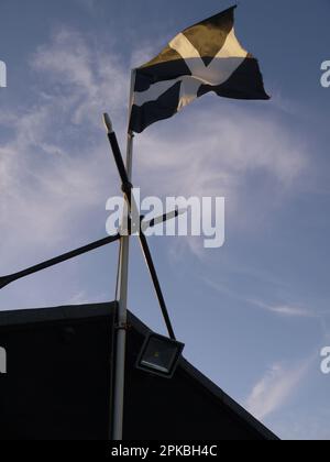 Vertical shot of a Cornish flag flying above Bude Rowing Boats, Bude, Cornwall, UK Stock Photo