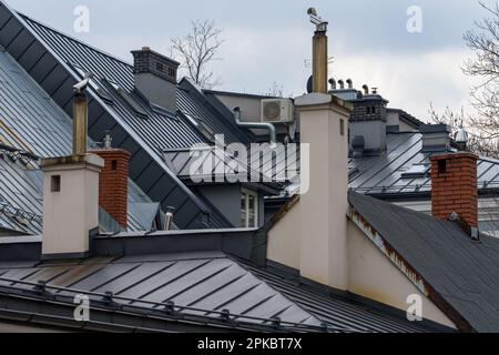 Roofs of tenement houses covered with sheet metal, gray metal roof, chimneys Stock Photo