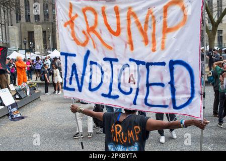 Anti-Trump supporter holds Trump indictment sign outside Manhattan Criminal Court House, NYC, during Trump arraignment on 04 April 2023. Stock Photo
