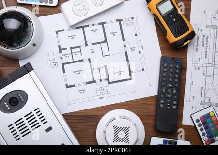 Flat lay composition with building plan and equipment for home security system on wooden table Stock Photo
