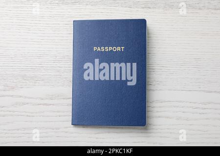 Blank blue passport on white wooden table, top view Stock Photo