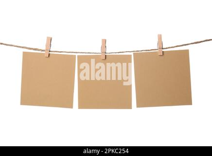 Clothespins with empty notepapers on string against white background. Space for text Stock Photo