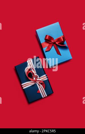 Gift boxes isolated on red background. Two blue gift boxes with bows. View from above Stock Photo