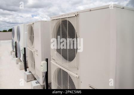 Air conditioning (HVAC) on the roof of an industrial building with blue sky and clouds. Stock Photo