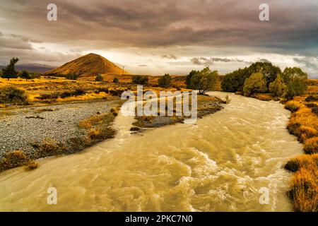 A swollen stream after heavy rain the high country at Lake Tekapo Stock Photo