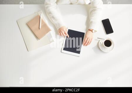 Woman operating tablet while sitting at desk Stock Photo