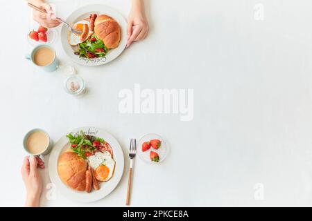 Hands of two people eating facing each other Stock Photo