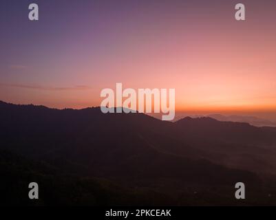 aerial view amazing colors in the sky at dawn over the misty sea in the valley.  colorful sky at twilight above the mountain range.  Mist covers the c Stock Photo