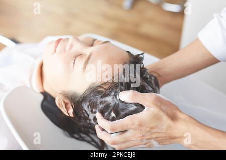 A woman having her hair washed on the shampoo table Stock Photo