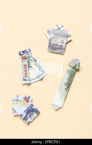 Origami clothes made of dollar banknotes on beige background Stock Photo