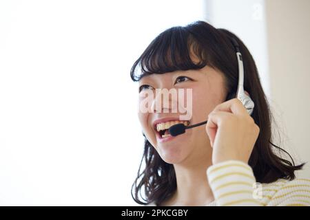 Woman wearing headphones and talking with a smile Stock Photo