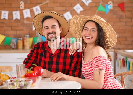 Young couple celebrating Festa Junina (June Festival) in kitchen Stock Photo