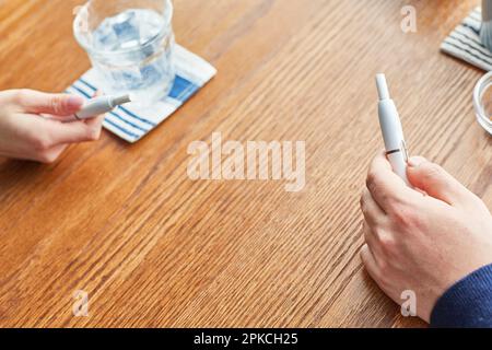 Male and female hand with Icos having tea at a café Stock Photo