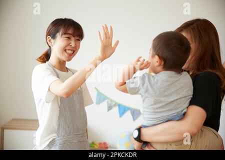 Child care worker waving to a child coming home Stock Photo