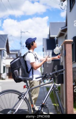 Delivery driver man pushing empty trolley across a road after ...