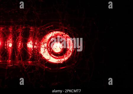 light from a red lantern shines through broken glass macro photo as a background Stock Photo