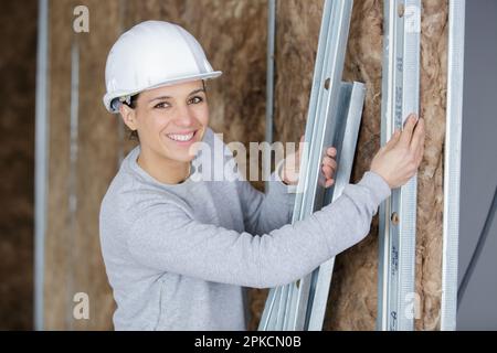 happy female factory worker moves metal bars in a factory Stock Photo