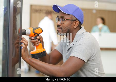man drilling wall in a hospital Stock Photo
