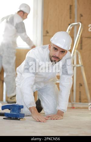 builder using sander on floor Stock Photo