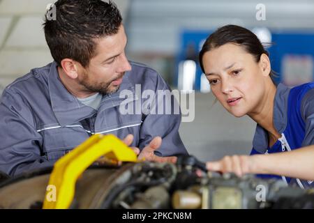 trainee of car-service mechanic listening to manager Stock Photo