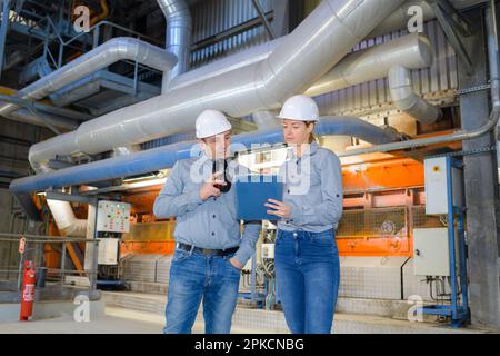 factory supervising workers having conversation Stock Photo