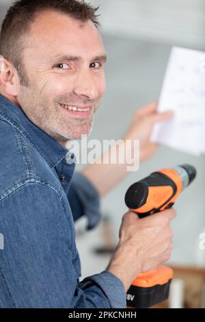 casual man reading instruction manual for power tool Stock Photo