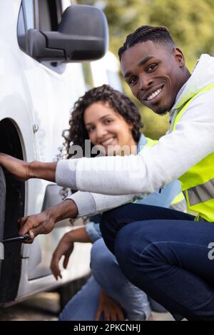 couple after a car breakdown changing the wheel Stock Photo