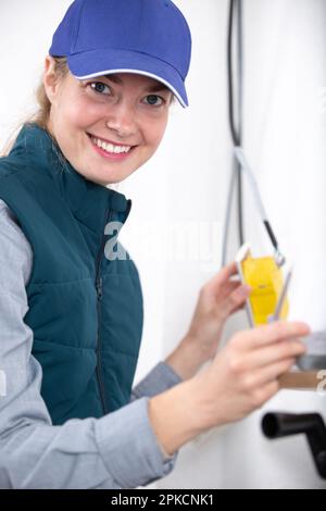 female electrician fixing socket electricity problem Stock Photo