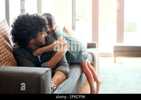 Big hugs for Daddy. a father and his little daughter bonding together at home. Stock Photo