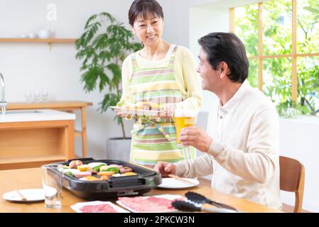 A middle-aged couple eating Yakiniku with draft beer Stock Photo