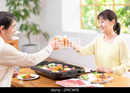 A middle-aged couple eating Yakiniku with draft beer Stock Photo
