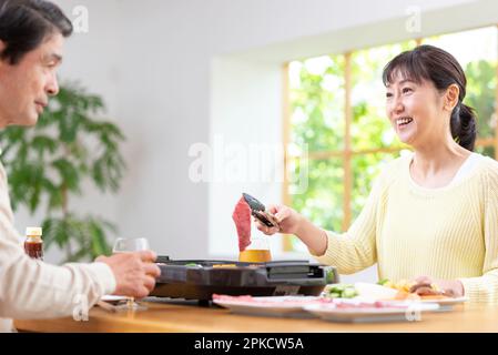 A middle-aged couple eating Yakiniku with draft beer Stock Photo