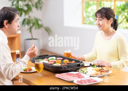 A middle-aged couple eating Yakiniku with draft beer Stock Photo